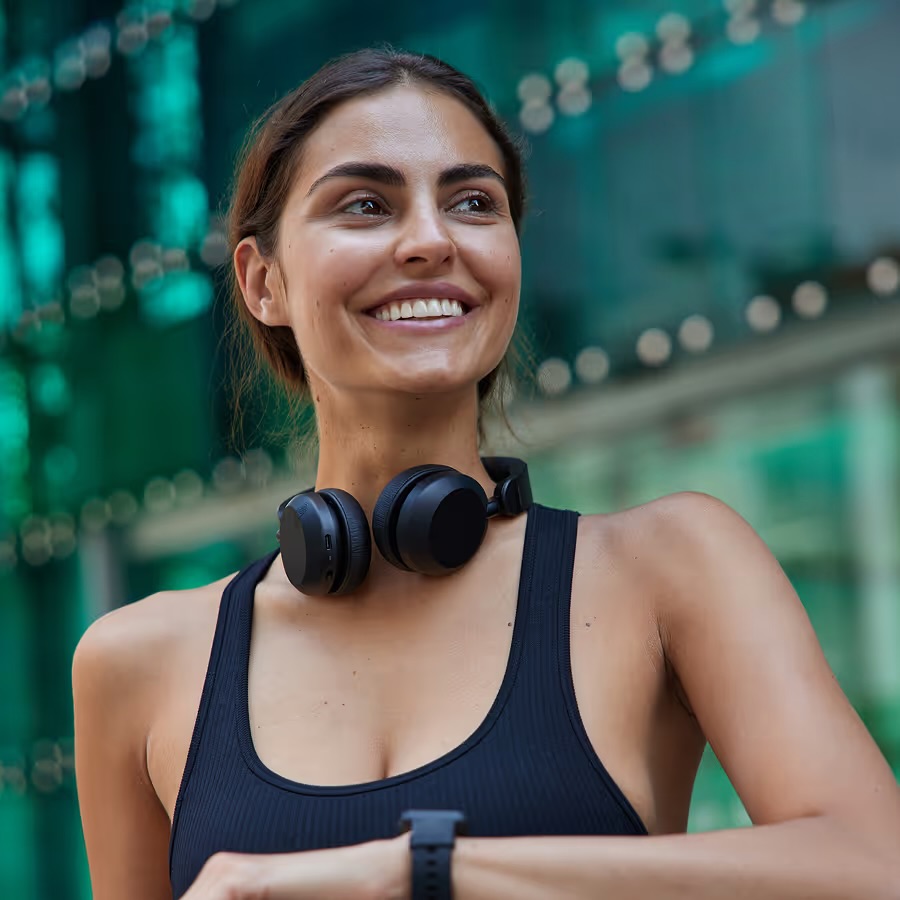 Smiling woman wearing headphones and a fitness watch